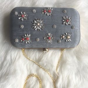 Grey clutch with white and red stones